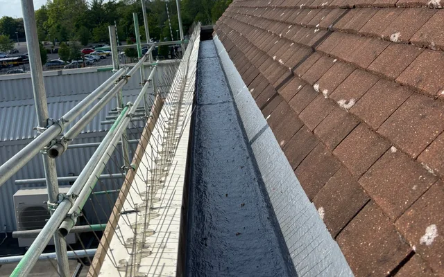 Lined box gutter beside the pitched roof at the Camberley retail building